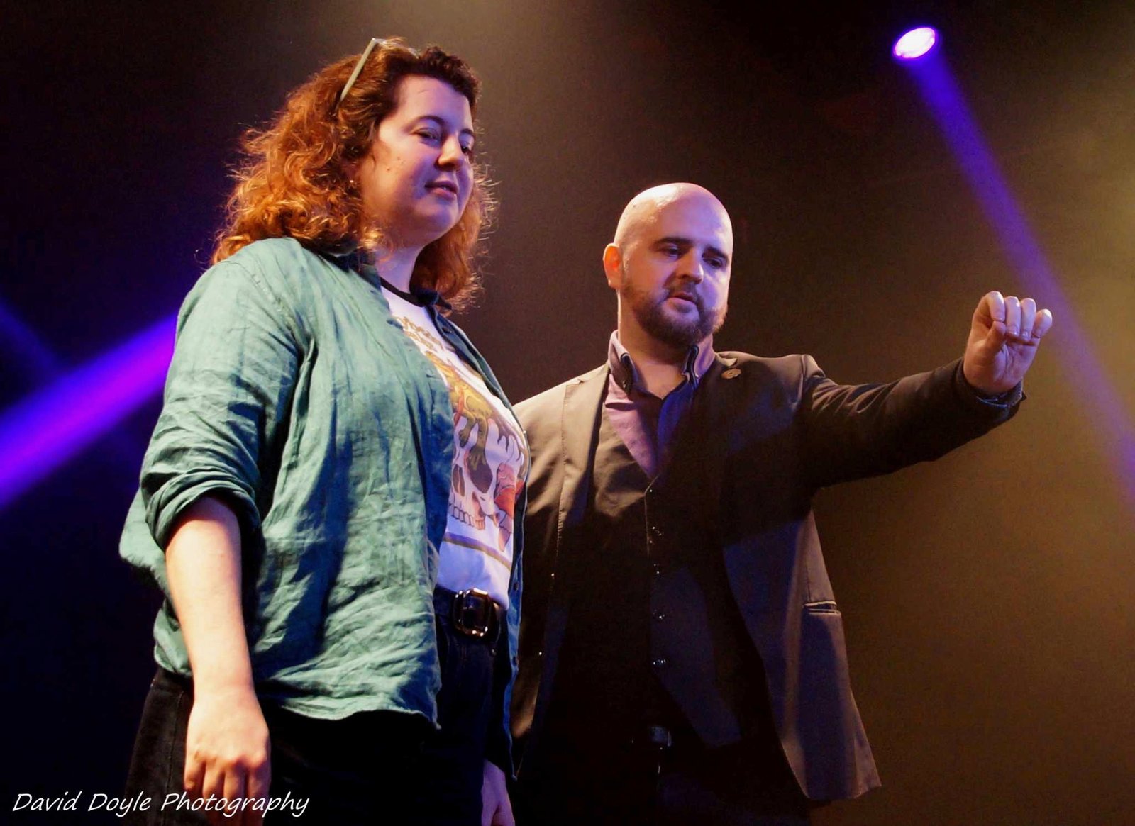 A workshop participant on stage with David Peace, who is gesturing while speaking